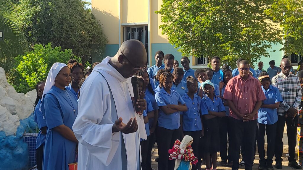 Sous le regard bienveillant de la Vierge Marie, le Père Abraham anime un moment de prière avec les élèves de l’AMJ.